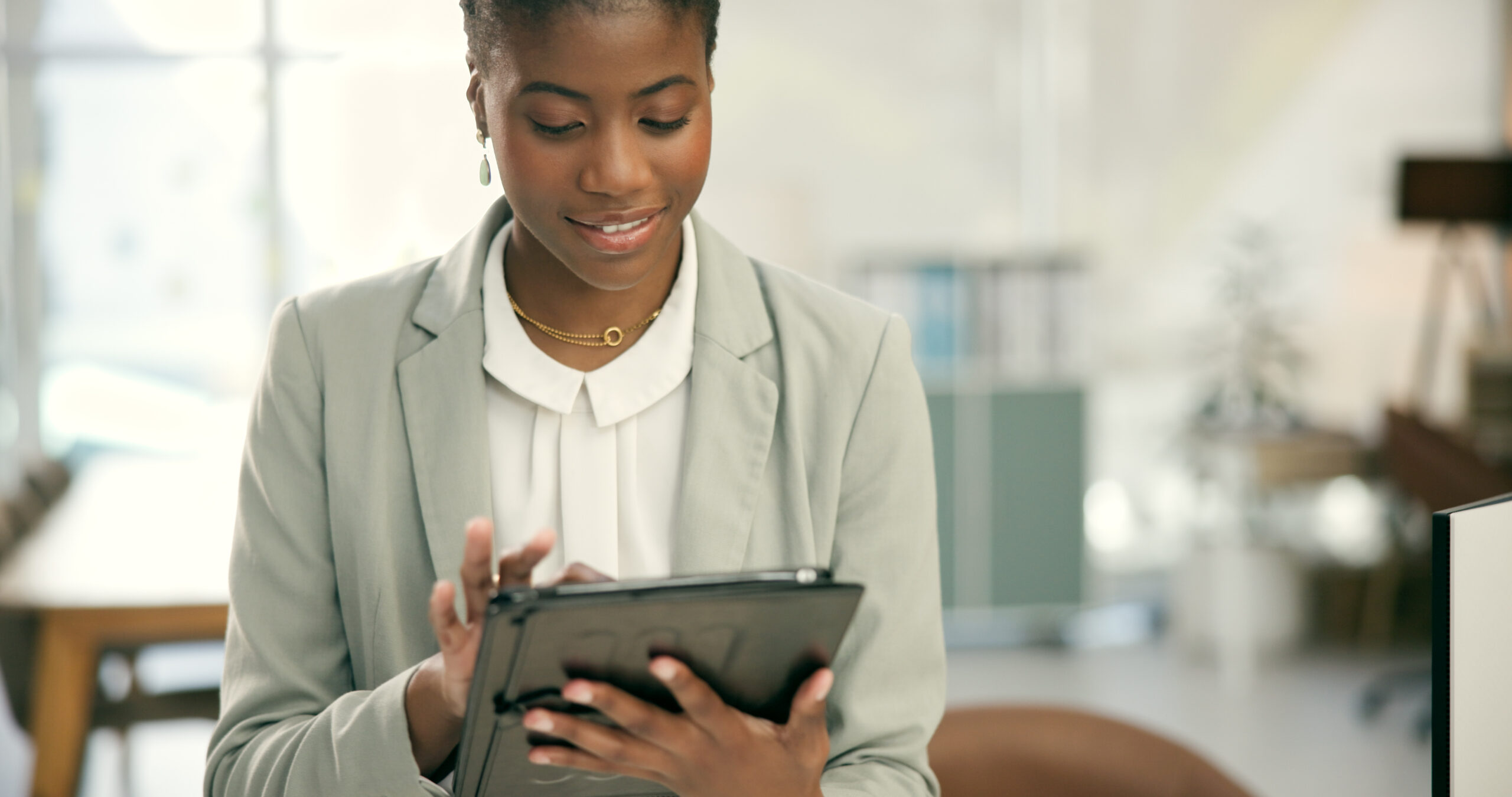 Professional woman scrolling through her tablet and reading.