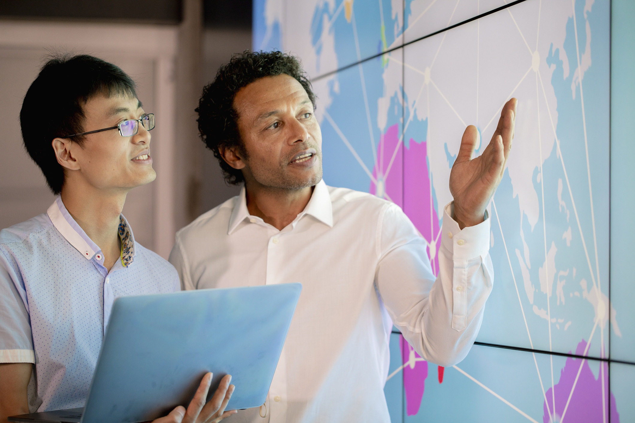 Businessmen looking at a world map and focusing on Asia.