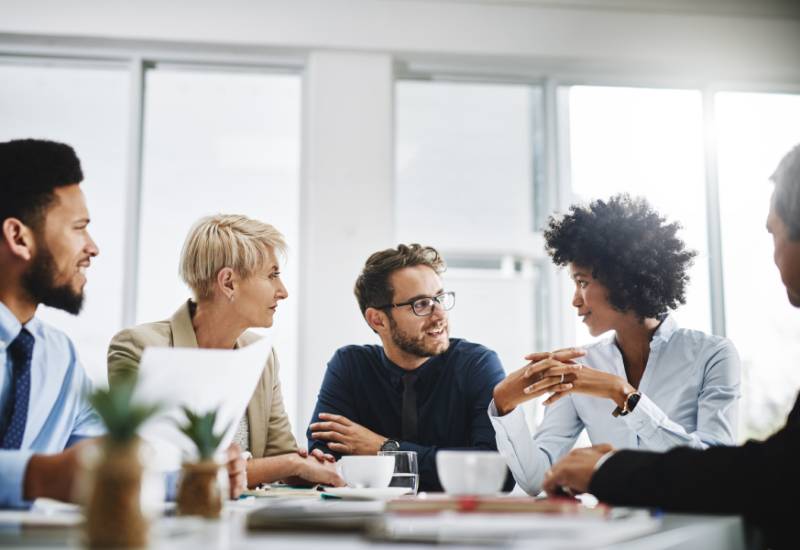 Diverse group of business professionals having a meeting sitting at a table.