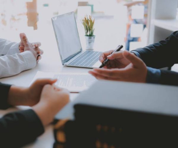 Close up concept of businessman sitting across the table from colleagues and giving a consultation.
