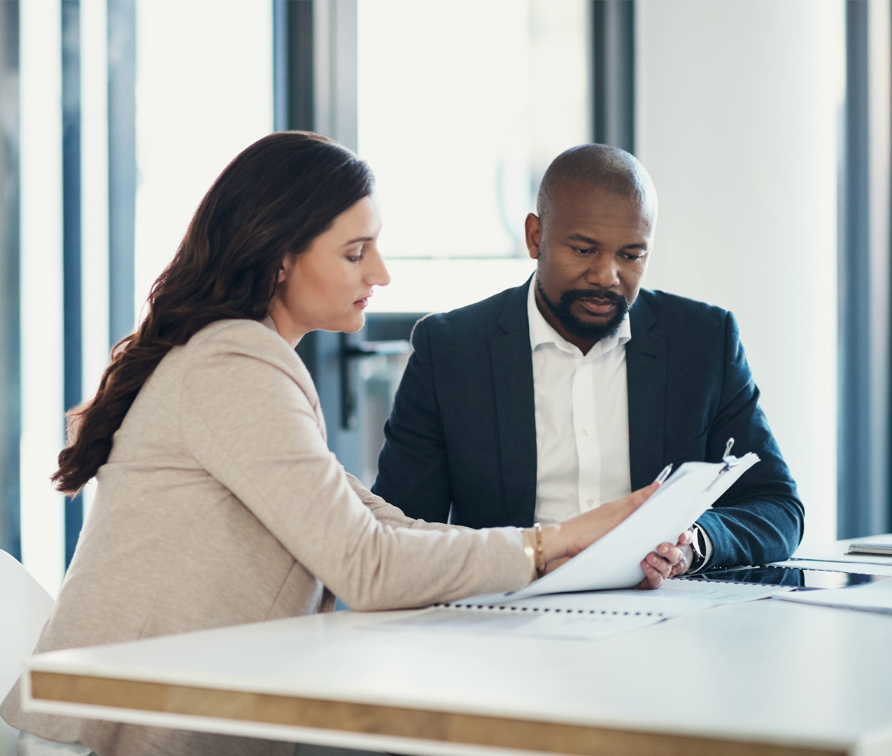 Two business people reading a regulatory document