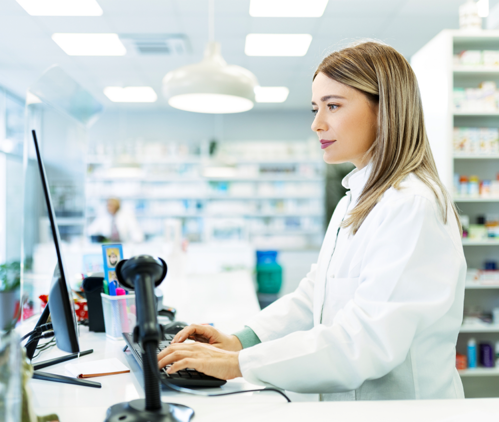 Female pharmacist typing on a computer in the pharmacy