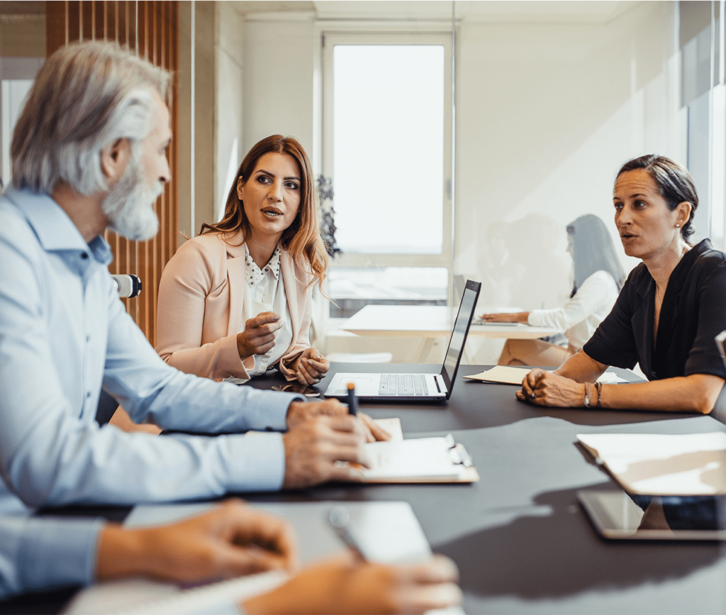 Business team huddles around a table and has a discussion in a meeting.