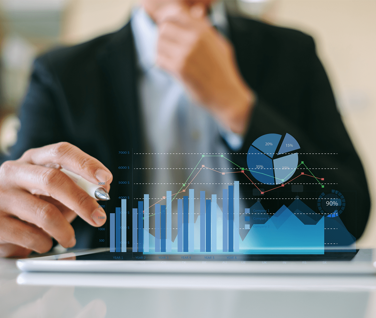 Business man looking at a tablet on the table and thinking as he studies the charts and graphs popping out of the screen.