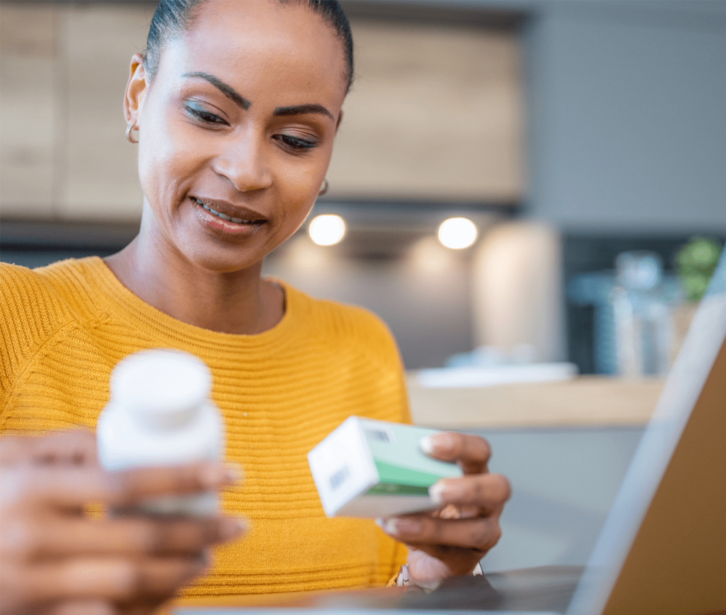 Middle-aged woman reviews her prescription bottle and packaging in detail.