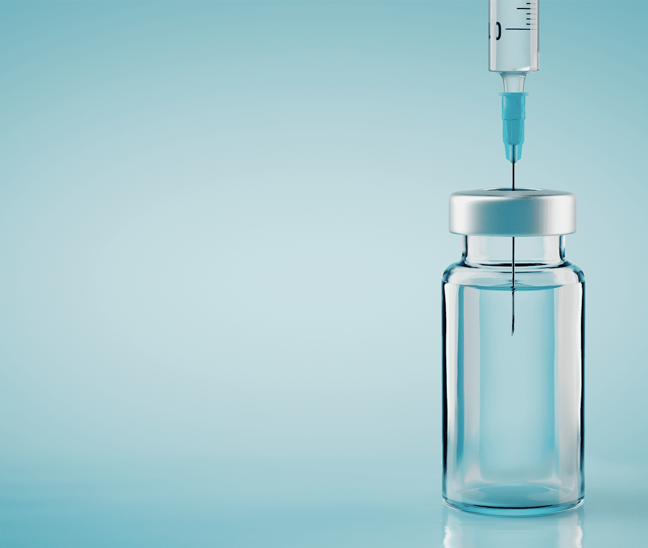 Syringe sticking in vaccine vial amongst a blue background.