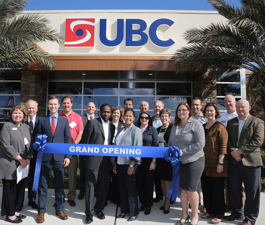 Group photo of the UBC team standing outside of the new office location in Florida